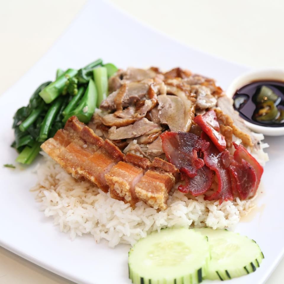 Pattaya Bay Thai Restaurant's rice dish with crispy pork, red pork, duck, and green vegetables.